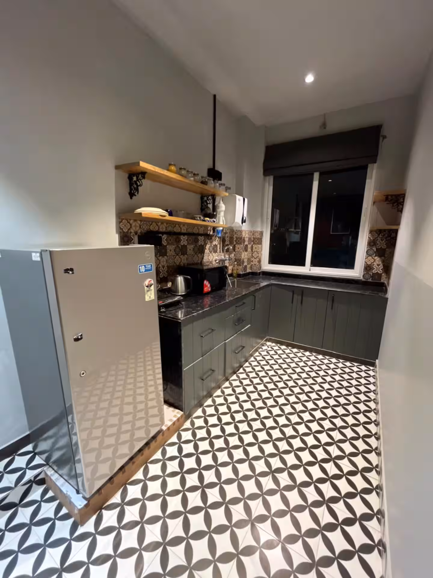 Guest kitchen with refrigerator, counter and patterned tile floor at Polaris Royal Terrace, Jaipur