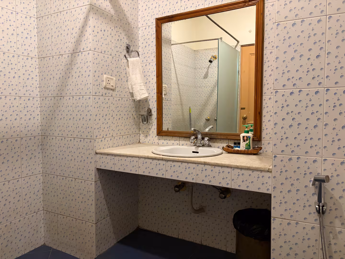 Tiled attached bathroom with vanity and fresh towels at Polaris Himalayan Chalet, Manali