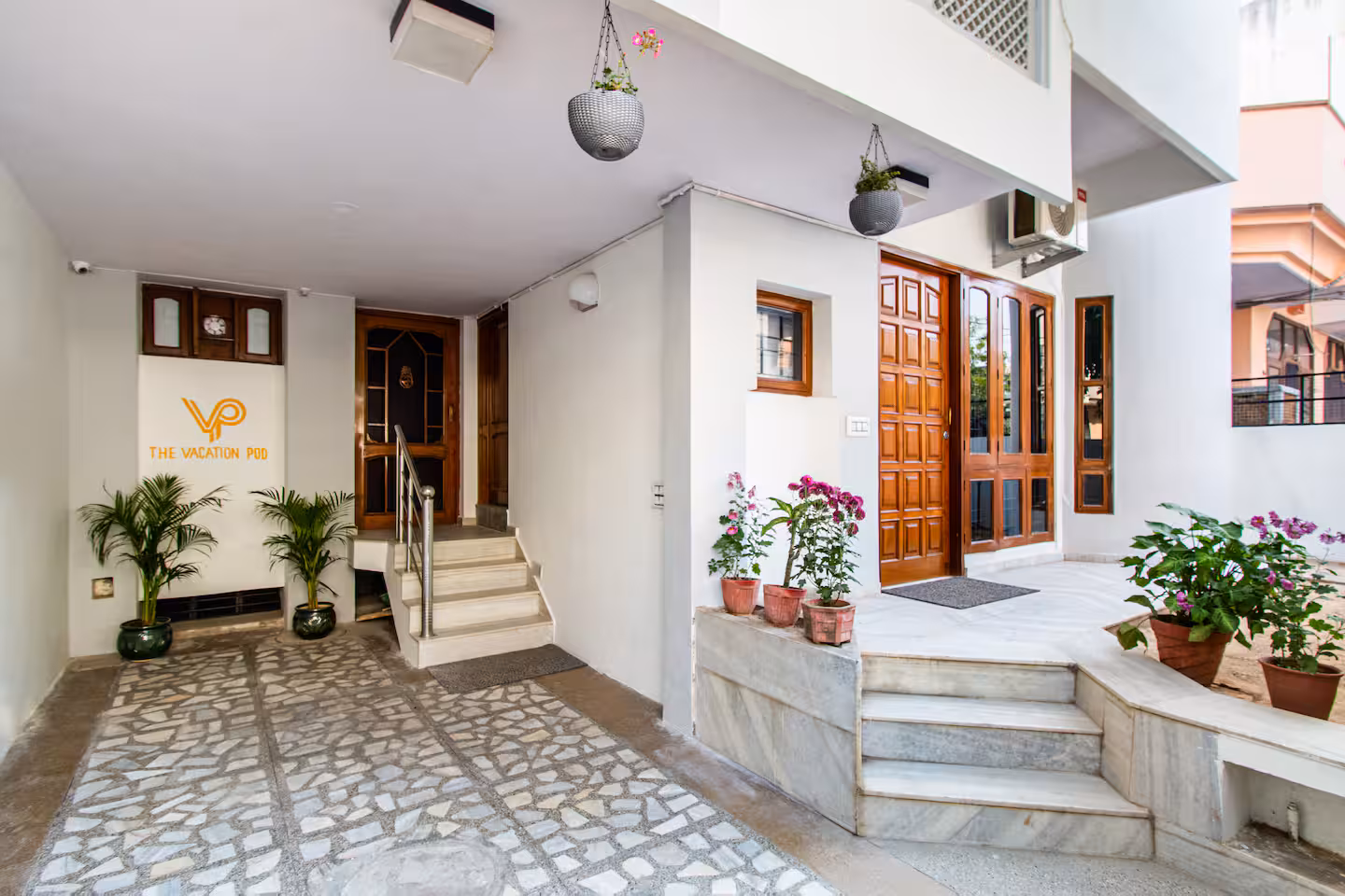 Private entrance and porch with steps and potted plants at Polaris Art Terrace, Jaipur