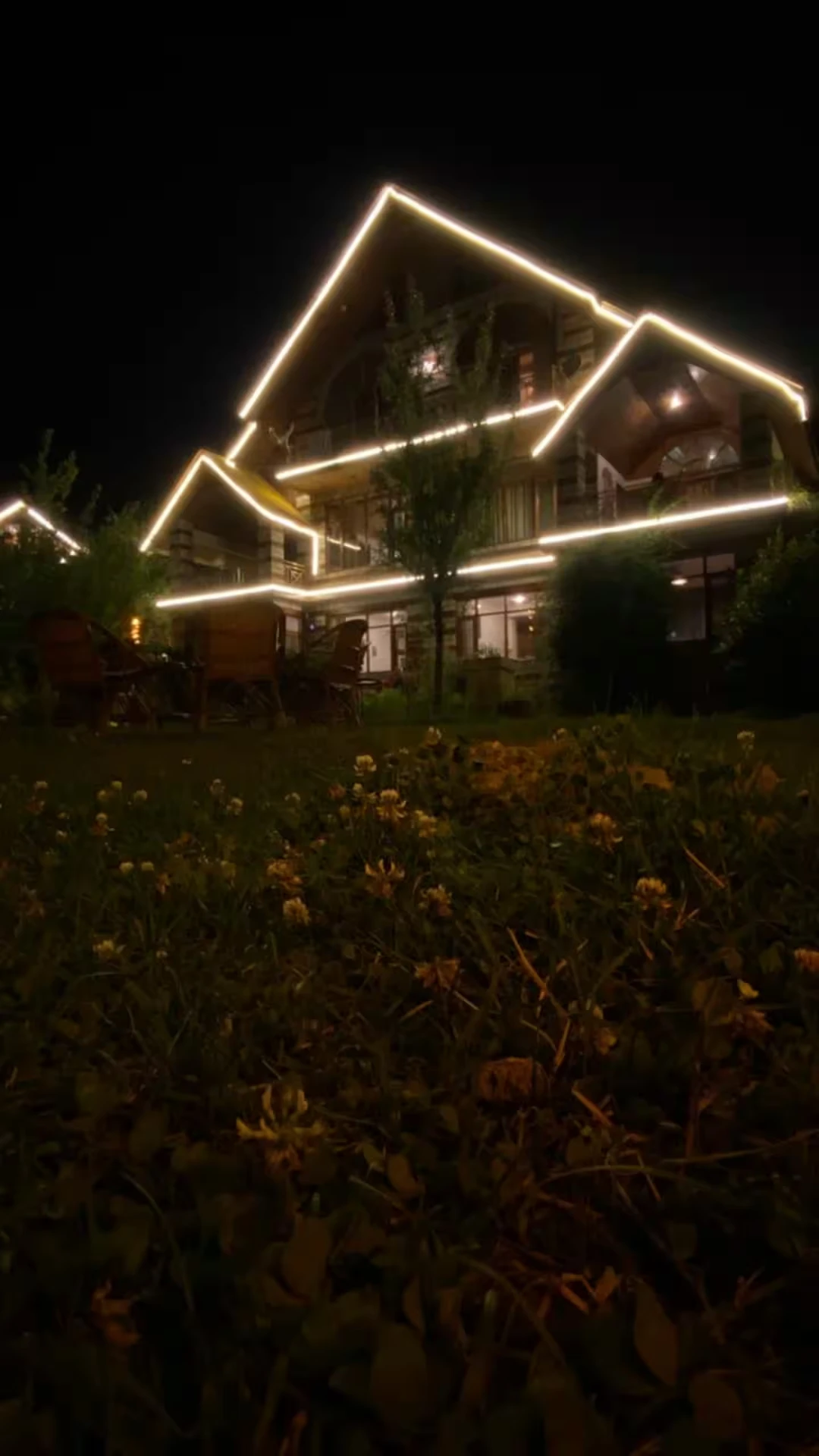 Polaris Himalayan Chalet lit up at night above its private lawn in Simsa, Manali