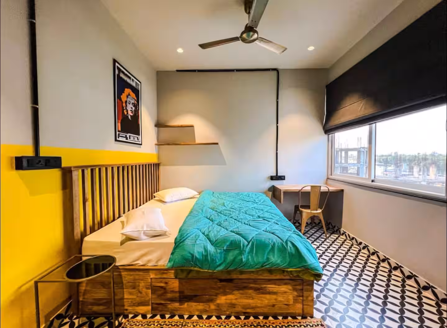 Bedroom with wooden bed, workspace desk and large window at Polaris Royal Terrace, Jaipur