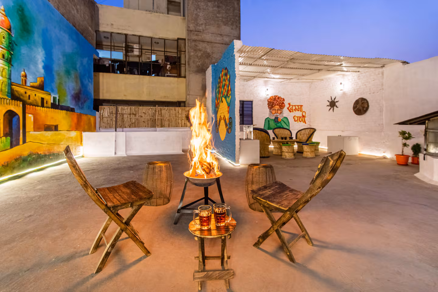 Bonfire and wooden folding chairs on the private terrace in the evening at Polaris Art Terrace, Jaipur