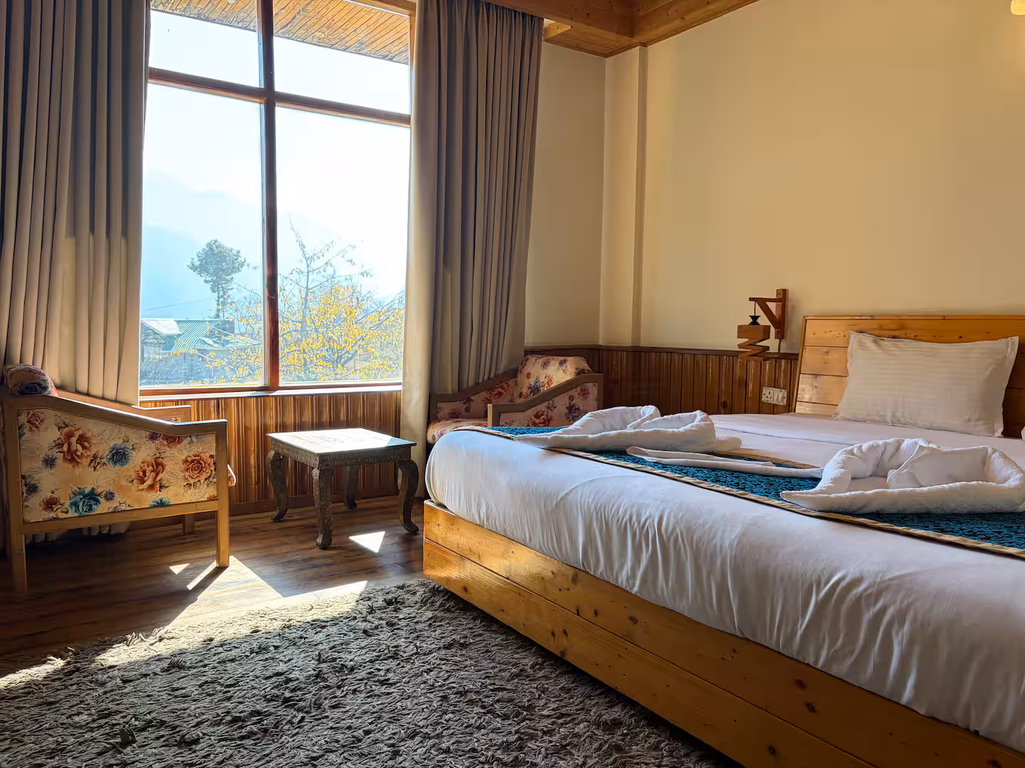 Bedroom window framing the valley at Polaris Himalayan Chalet, Manali
