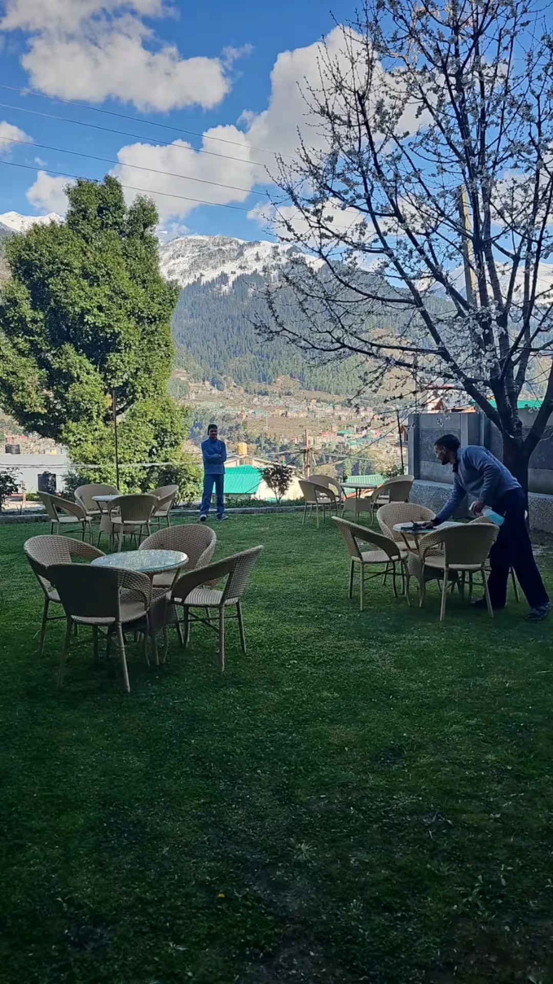 Garden and seating at Polaris Golden Wood, Manali, with snow-capped Himalayan peaks beyond