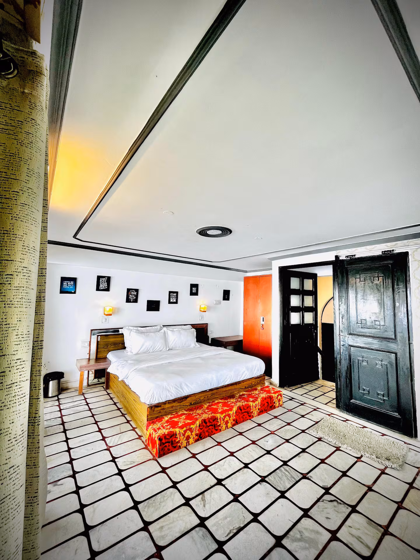 Upper-floor bedroom with vaulted ceiling and patterned flooring at Polaris Alpine, Mussoorie