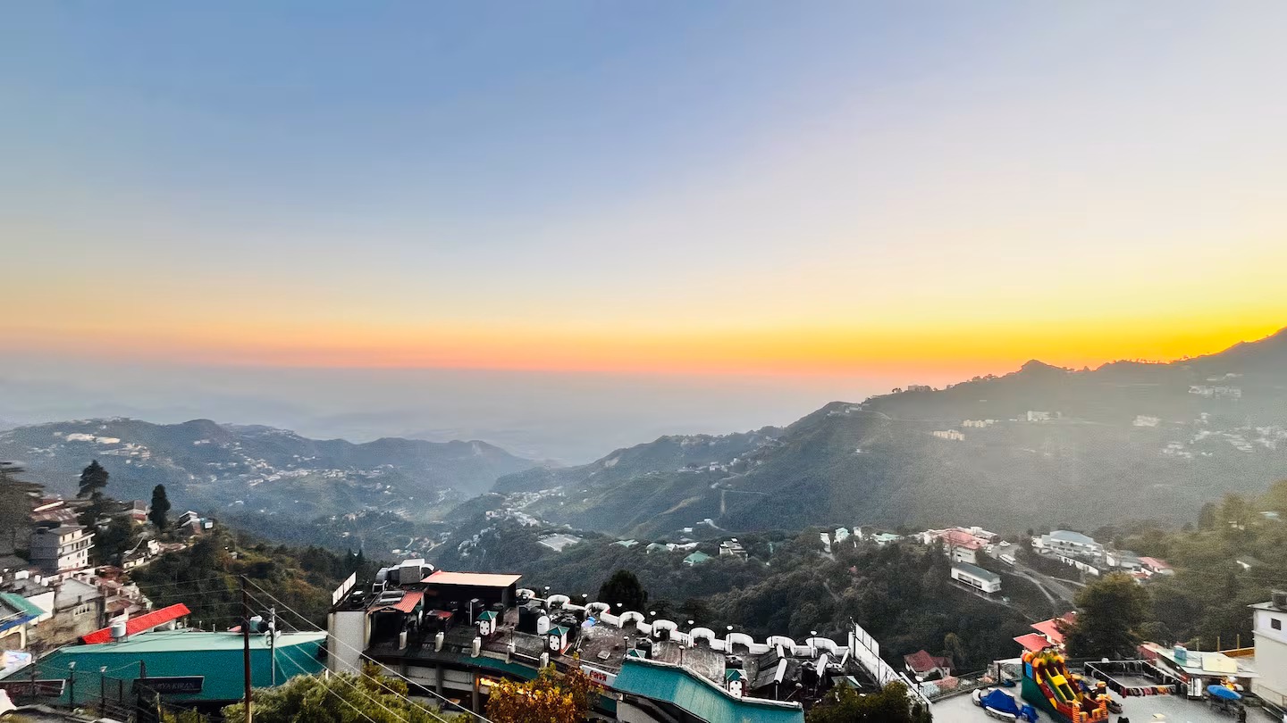 Panoramic sunset view over the Mussoorie valley and Himalayan ridgelines from the terrace at Polaris Alpine, Mall Road