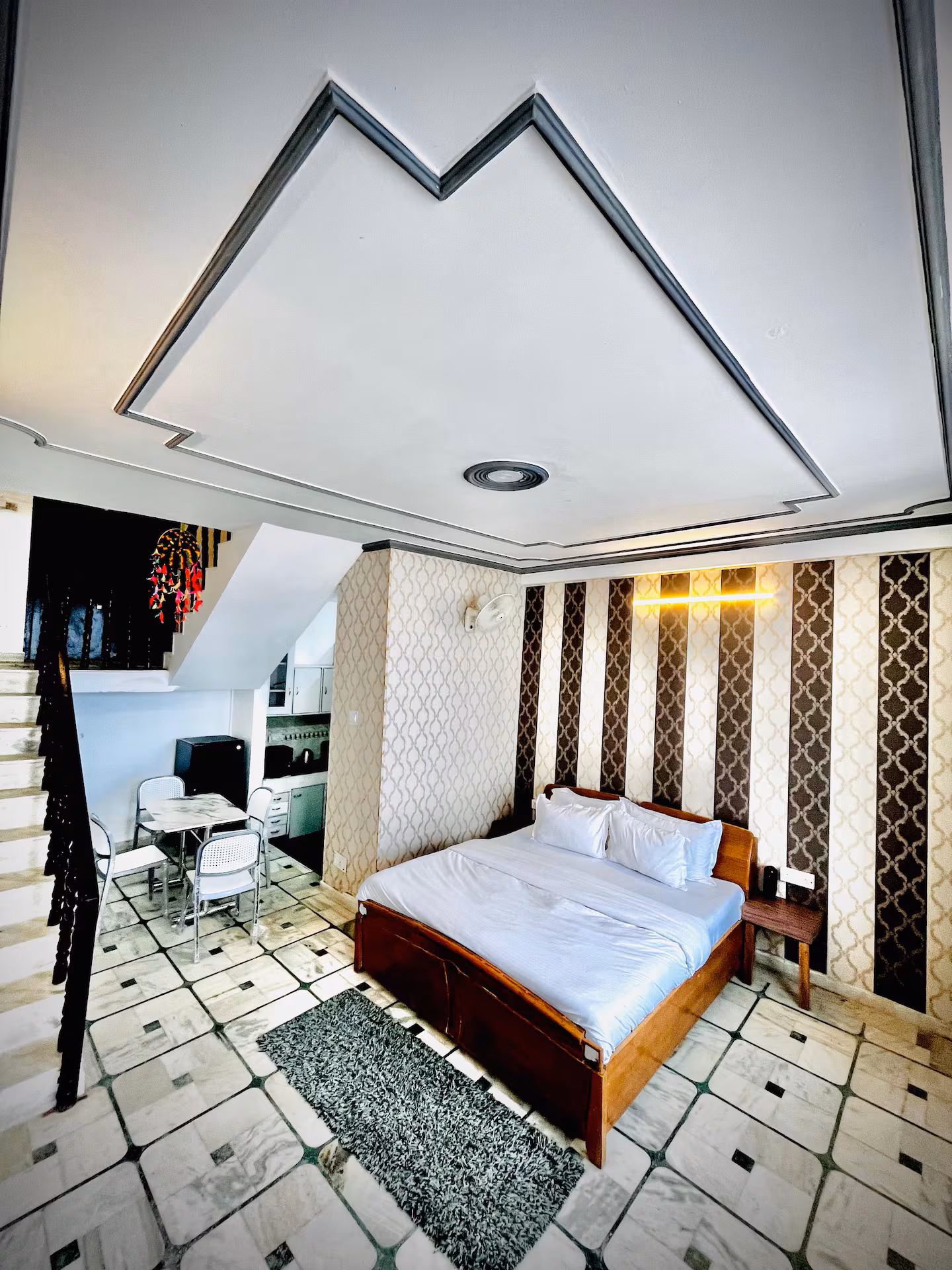 Second bedroom with mountain-motif ceiling detail and workspace at Polaris Alpine, Mussoorie