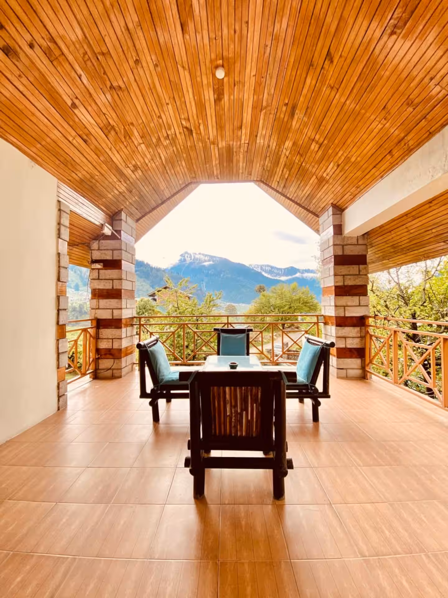 Arched timber balcony with seating overlooking the Manali mountains at Polaris Himalayan Chalet