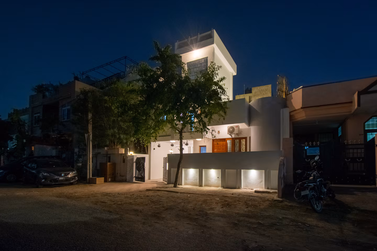 Exterior of the villa lit at night with parking space in front at Polaris Art Terrace, Jaipur