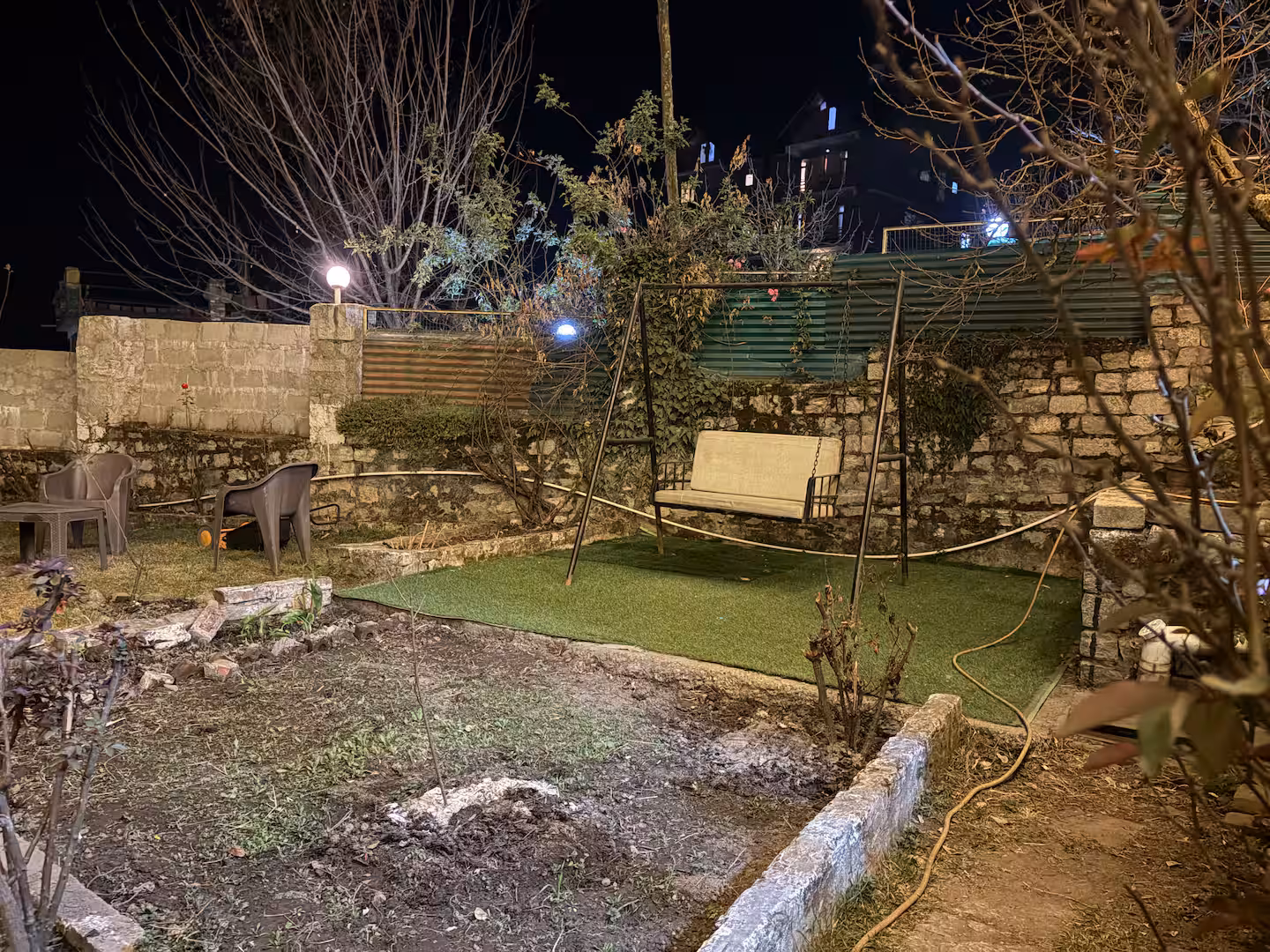 Garden swing and lawn seating in the evening at Polaris Himalayan Chalet, Manali