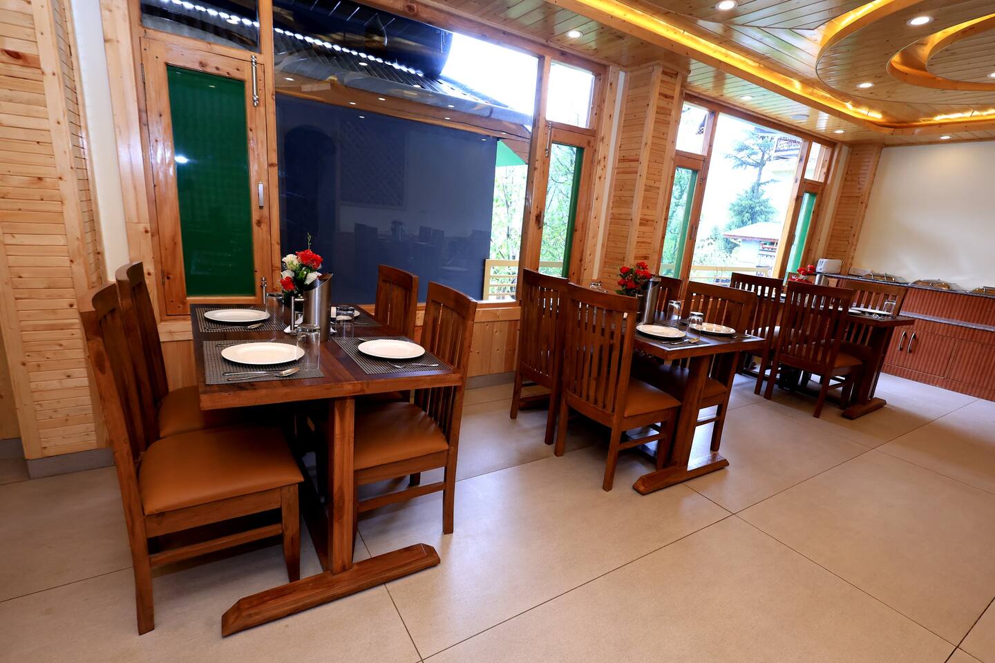 Wooden dining room with wide windows framing the Manali valley at Polaris Golden Wood