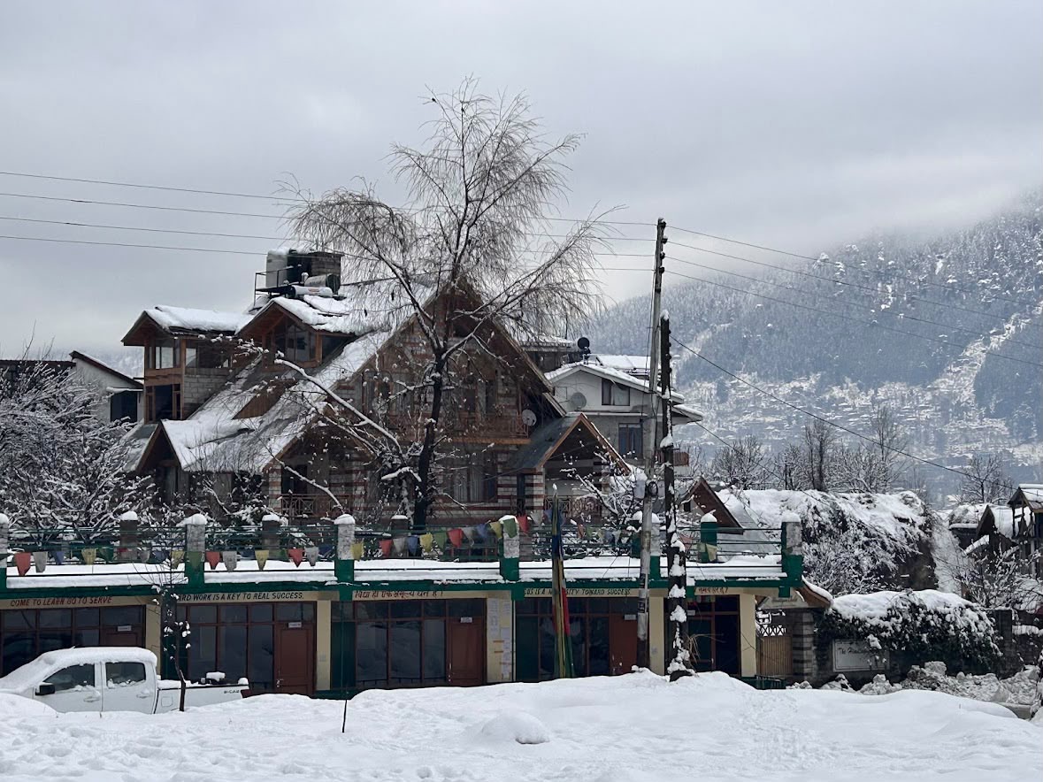 Snow-covered exterior of a Polaris stay in Manali